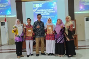 Kenzie (kiri, baju merah) dan Yessie (kanan, baju merah), dua siswa SMPN 2 Sentolo yang sabet juara OSN SMP Kabupaten 2026 bersama Kepala Dinas Dikpora Kabupaten Kulon Progo, Drs. Nur Wahyudi, M.M (tengah) dan para guru. (Dok Dikpora Kulon Progo)